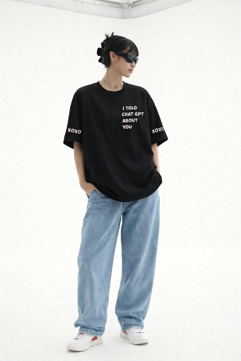 Person wearing a black t-shirt with text and light blue jeans on a white background